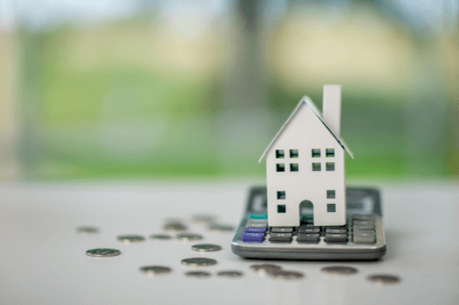House model on calculator with coins – mortgages for first-time buyers with low deposits in Warwickshire