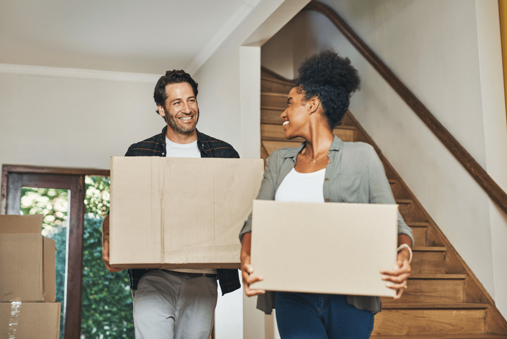 first time buyers carrying boxes into their new home